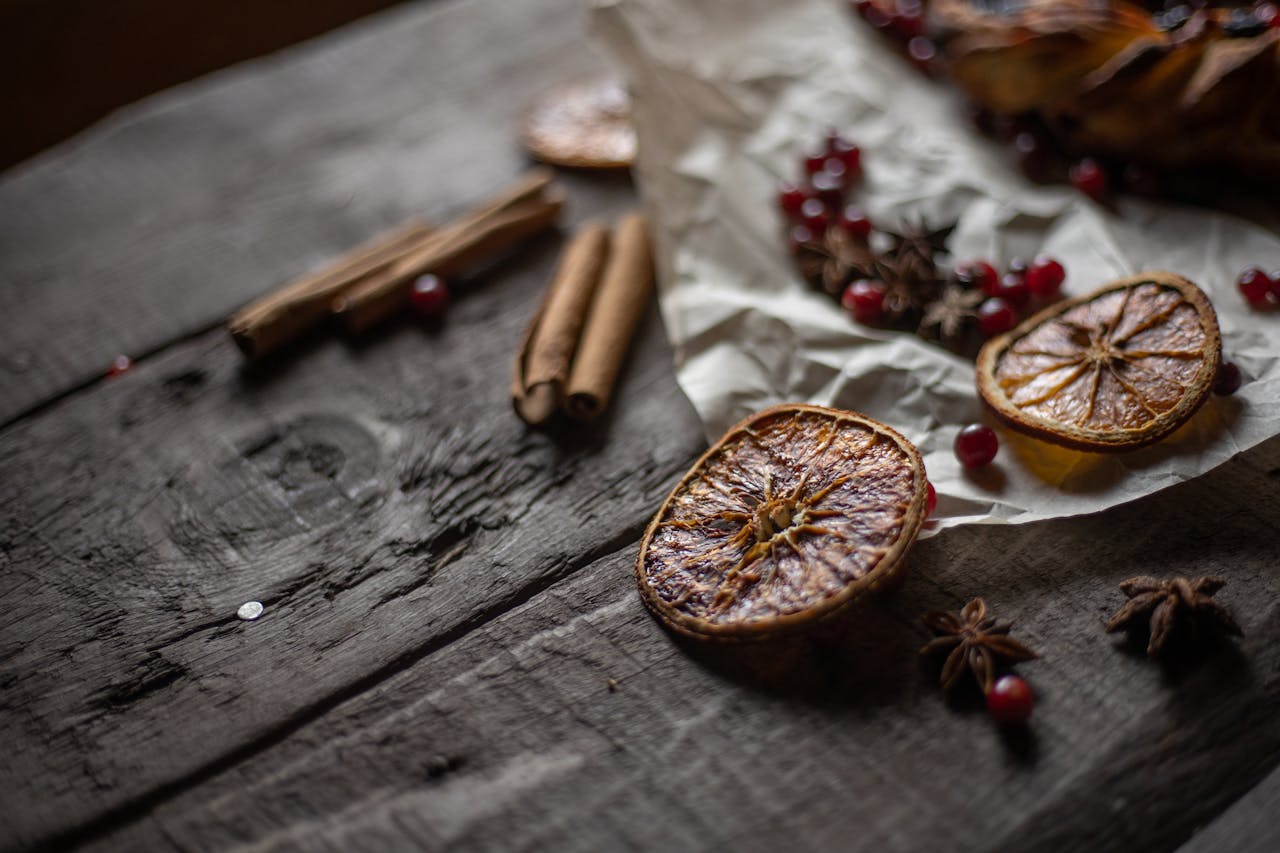 category-04 A rustic still life of dried orange slices, cinnamon sticks, and star anise on a wooden table.