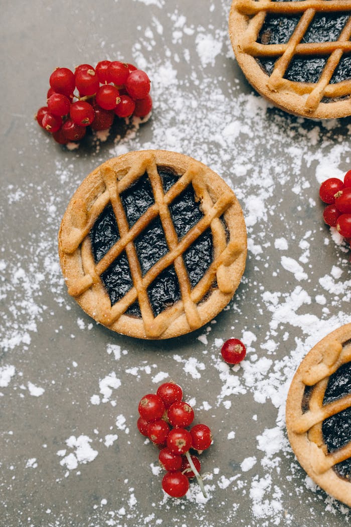 journey A delectable berry tart with lingonberries, captured in an artistic overhead shot.